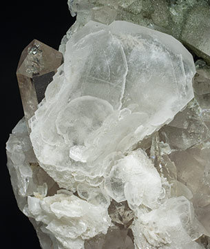 Calcite (variety papierspat) with Quartz (variety smoky quartz) and Chlorite. 